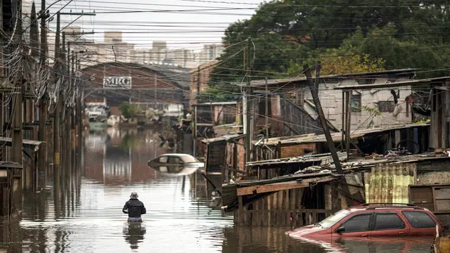 epa11364736 A woman walks in the middle of a flood affected area in the city of Porto Alegre, in Rio Grande do Sul, Brazil, 23 May 2024. Residents in southern Brazil began cleaning their homes in cities and neighborhoods where river levels have dropped, almost three weeks after the onset of unprecedented flooding. In Porto Alegre, the capital of the state of Rio Grande do Sul, the Guaiba River dropped to 3.90 meters still 90 centimeters above flood level, but a significant reduction from the record 5.35 meters reached in early May. EPA/Daniel Marenco