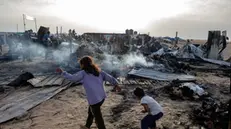 epa11372895 Palestinians inspect the damage after an Israeli army raid on a camp at an area designated for displaced people in Rafah, southern Gaza Strip, 27 May 2024. At least 40 people were killed after Israeli airstrikes hit an area in Rafah designated for the displaced, the Palestinian Civil Defense said. More than 35,000 Palestinians and over 1,400 Israelis have been killed, according to the Palestinian Health Ministry and the Israel Defense Forces (IDF), since Hamas militants launched an attack against Israel from the Gaza Strip on 07 October 2023, and the Israeli operations in Gaza and the West Bank which followed it. EPA/HAITHAM IMAD