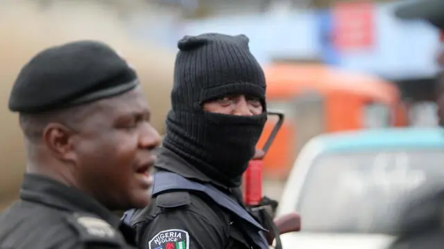 epa09534457 A policeman is seen wearing a hood during a memorial protest for a military attack at the Lekki tollgate in Lagos, Nigeria, 20 October 2021. Police disperse youths who held a memorial protest in Lagos to commemorate a military attack during the protest against police brutality on 20 October 2020. EPA/AKINTUNDE AKINLEYE