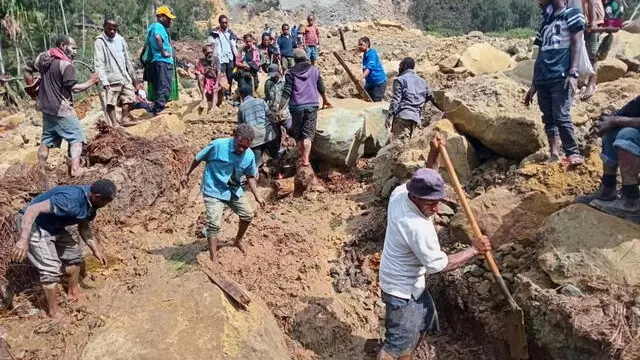 epa11373826 A handout photo made available by the International Organzation for Migration (IOM), shows local inhabitants digging in the rubble using spades and wooden sicks to serach for missing relatives at the landslide site in Tuliparo village, Yambali Ward, Maip Muli LLG, Porgera District,Papua New Guinea, 26 May 2024. (Issued 27 may 2024). According to a senior official with the IOM, on 26 May, more than 670 people are feared dead, after a landslide hit the Higlands region of Papua New Guinea on early 24 May. " the community in Yambali village, situated at the foot of a mountain in the remote Enga Province, is buried under between six to eight metres of soil. 150 houses are believed to be buried" he added. EPA/MOHAMUD OMER/IOM/ HANDOUT HANDOUT EDITORIAL USE ONLY/NO SALES HANDOUT EDITORIAL USE ONLY/NO SALES