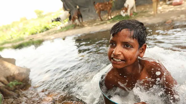 epa11381324 A boy bathes to cool himself in a tubewell on a hot day at the fields in New Delhi, India, 31 May 2024. The India Meteorological Department (IMD) has issued a heat red alert for Delhi, Rajasthan, Haryana, Punjab, and Madhya Pradesh. The IMD Director General M Mohapatra said they are checking the temperature sensor in Delhi's Mungeshpur automatic weather station to see if it is working properly, as there were temperatures of over 50 degrees Celsius recorded on 29 May, and the weather department has reported that the maximum temperature is anticipated to reach around 44 degrees Celsius, in the Indian capital. EPA/HARISH TYAGI