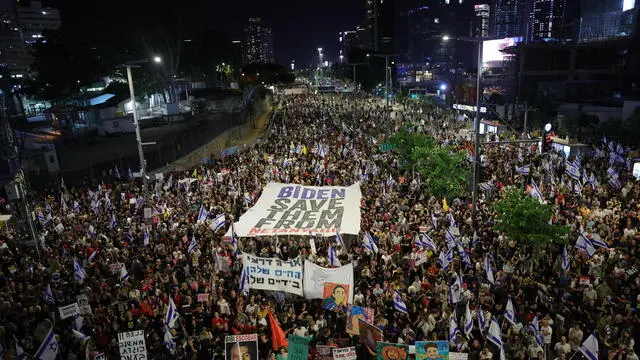 epaselect epa11384189 Protesters carrying a large banner take to the streets to call on the Israeli cabinet to sign a hostage deal and hold early elections during a demonstration outside the Kirya military headquarters in Tel Aviv, Israel, 01 June 2024. According to the Israeli military, 125 Israeli hostages are still held by Hamas in the Gaza Strip. The protest comes a day after an announcement by US President Biden on 31 May urging Israel and Hamas to accept a new deal for a permanent ceasefire that includes ending the military operations in Gaza and the return of the Israeli hostages. EPA/ABIR SULTAN