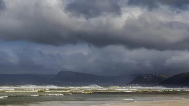 epa05281391 A north westerly wind fans waves breaking on Muizenberg beach as a storm front approaches Cape Town, South Africa 28 April 2016. The Western Cape Disaster Management Centre has warned of cold conditions with rain and snow with a possible risk of floods from the second big winter front hitting the Cape. EPA/NIC BOTHMA