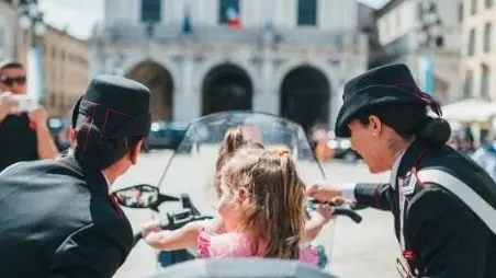 Due donne dell'Arma con una bambina in piazza Loggia