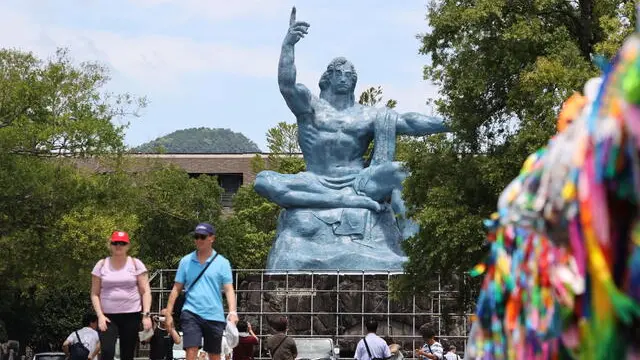 epa10790183 People visit Nagasaki Peace Park to offer prayers for victims of the atomic bombing of Nagasaki past the Peace Statue (Rear) in Nagasaki, southwestern Japan, 08 August 2023 after the city was forced to change schedule of the memorial service for victims due to typhoon Khanun. The ceremony marking the 78th anniversary of the atomic bombing was held without attendance of A-bomb survivors, Japan Prime Minister Fumio Kishida and diplomatic representatives. EPA/JIJI PRESS JAPAN OUT EDITORIAL USE ONLY/