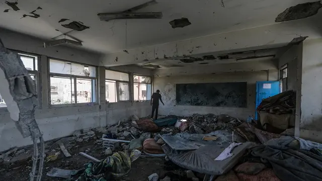 epa11392972 A Palestinians inspects the damages at a destroyed UNRWA school building following an Israeli airstrike in Al Nusairat refugee camp in the central Gaza Strip, 06 June 2024. According to the Palestinian News Agency Wafa, at least 32 people were killed and dozens others were injured on early 06 June following an Israeli strike on a UNRWA school sheltering displaced Palestinians, located in the Nuseirat refugee camp in the central Gaza strip. The Israeli army said that it had "conducted a precise strike on a Hamas compound", whose members were " embedded in the UNRWA school". More than 36,000 Palestinians and over 1,400 Israelis have been killed, according to the Palestinian Health Ministry and the Israel Defense Forces (IDF), since Hamas militants launched an attack against Israel from the Gaza Strip on 07 October 2023, and the Israeli operations in Gaza and the West Bank which followed it. EPA/MOHAMMED SABER