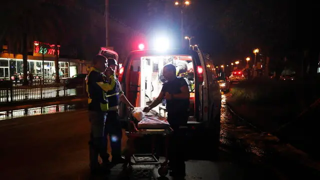 epa09192283 Medics stand in front of an ambulance a rockets attack, Tel Aviv, 11 May 2021. At least one woman was killed after 130 rockets fired by Hamas from Gaza strip fell on Tel Aviv and neighbouring cities. A day earlier and in response to days of violent confrontations between Israeli security forces and Palestinians in Jerusalem, various Palestinian militants factions in Gaza launched rocket attacks that killed two Israelis in the city of Ashkelon. Israel Defense Forces (IDF) said they hit over 100 targets in Gaza Strip during retaliatory overnight strikes. The Health Ministry of Gaza strip said that at least 26 Palestinian, including nine children, were killed from the Israeli airstrikes. Israeli Prime Minister Benjamin Netanyahu said on 11 May that they will increase the rate and intensity of the strikes. EPA/ATEF SAFADI