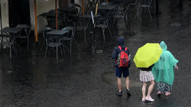 Passanti con ombrelli durante il temporale che si e' abbattuto a Roma, 13 giugno 2023 . ANSA/ETTORE FERRARI (turisti, ombrello, ombrelli, pioggia)