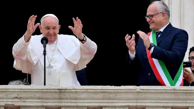 Pope Francis (L) is flanked by Rome's Mayor Roberto Gualtieri, blesses the faithful from a balcony during his visit to Campidoglio (Capitoline hill) in Rome, Italy, 10 June 2024. ANSA/ETTORE FERRARI