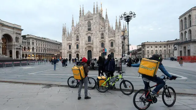 Alcuni riders in piazza del Duomo a Milano mentre attendono di cominciare a lavorare. Milano, 6 Marzo 2021. ANSA / MATTEO BAZZI