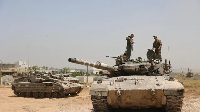 epa11357607 Israeli soldiers with their tanks gather at an undisclosed location near the border fence with the Gaza Strip, in southern Israel, 21 May 2024. The Israeli military stated on 21 May that they continued 'operational activities' throughout the Gaza Strip over the past day, where they dismantled some 70 targets. More than 35,000 Palestinians and over 1,400 Israelis have been killed, according to the Palestinian Health Ministry and the Israel Defense Forces (IDF), since Hamas militants launched an attack against Israel from the Gaza Strip on 07 October 2023, and the Israeli operations in Gaza and the West Bank which followed it. EPA/ABIR SULTAN