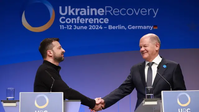 epa11403683 Ukrainian President Volodymyr Zelensky (L) and German Chancellor Olaf Scholz shake hands during a joint press conference within the Ukraine Recovery Conference 2024 in Berlin, Germany, 11 June 2024. The Ukraine Recovery Conference 2024 takes place in Berlin from 11 to 12 June 2024, under the slogan 'United in defense. United in recovery. Stronger together.' EPA/CLEMENS BILAN