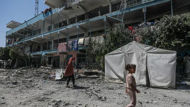 epa11392940 Internally displaced Palestinians walk in the courtyard of a destroyed UNRWA school following an Israeli air strike in Al Nusairat refugee camp in the central Gaza Strip on, 06 June 2024. According to the Palestinian News Agency Wafa, at least 32 people were killed and dozens others were injured on early 06 June following an Israeli strike on a UNRWA school sheltering displaced Palestinians, located in the Nuseirat refugee camp in the central Gaza strip. The Israeli army said that it had "conducted a precise strike on a Hamas compound", whose members were " embedded in the UNRWA school". More than 36,000 Palestinians and over 1,400 Israelis have been killed, according to the Palestinian Health Ministry and the Israel Defense Forces (IDF), since Hamas militants launched an attack against Israel from the Gaza Strip on 07 October 2023, and the Israeli operations in Gaza and the West Bank which followed it. EPA/MOHAMMED SABER