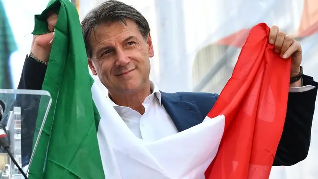 epa11420774 Leader of Italian movement "Movimento 5 Stelle" (Five Stars Movement / M5S), Giuseppe Conte holds an Italian flag at the demonstration against the reforms of the Premiership and Autonomy promoted by the opposition parties in Rome, Italy, 18 June 2024. EPA/ETTORE FERRARI