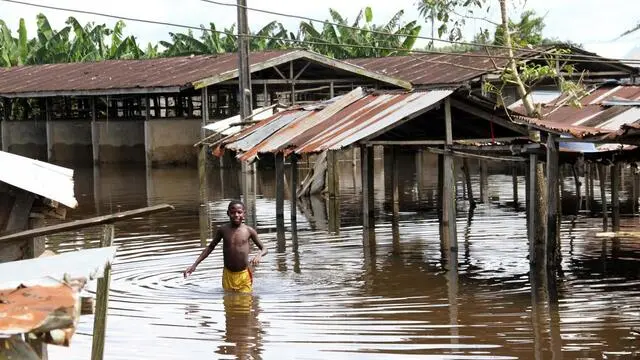 epa03432194 A boy wades through a flooded market in Agadama in Ughelli north local government council in the oil rich Niger delta region, Nigeria, 13 October 2012. The floods in the region, which have been the worst in decades, have killed 140 people and left hundreds of thousands homeless. A food crisis is also feared, according to local sources. EPA/GEORGE ESIRII