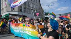 epa09362587 Participants hold a banner during the gay pride parade in downtown Budapest, Hungary, 24 July 2021. EPA/SZILARD KOSZTICZAK HUNGARY OUT