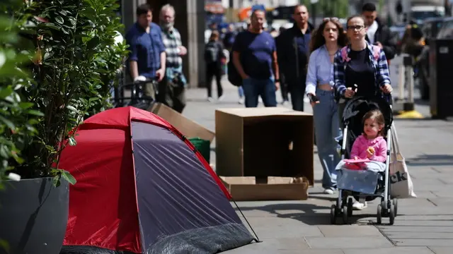 epa11393387 Pedestrians walk past a homeless person's tent in London, Britain, 06 June 2024. EPA/ANDY RAIN