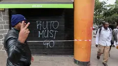 epa11438979 A man gestures as he walks past a tag that reads 'Ruto must go' in Nairobi, Kenya, 26 June 2024. At least 13 people were killed during a nationwide strike against tax hikes that turned deadly on 25 June 2024, according to the Kenya Medical Association. Kenyan President William Ruto warned his government would use all means at its disposal to prevent a repeat of the violence. EPA/DANIEL IRUNGU