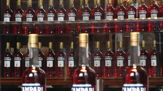 Bottiglie di Campari esposte sulla vetrina del bar Camparino in Galleria Vittorio Emanuele, Milano, 18 febbraio 2020. Campari ha chiuso il 2020 con vendite nette per 1.772 milioni di euro, in calo del 3,8% sul 2019 (-4,1% a livello organico), con una flessione più sostenuta, il 7% a livello organico, nel quarto trimestre per effetto dei nuovi lockdown. L'utile netto, si legge in una nota, si è attestato a 187,9 milioni, in calo del -39,1% dopo rettifiche operative, finanziarie e fiscali per 14,2 milioni senza le quali il calo sarebbe stato contenuto al 24,4%. ANSA/DANIEL DAL ZENNARO