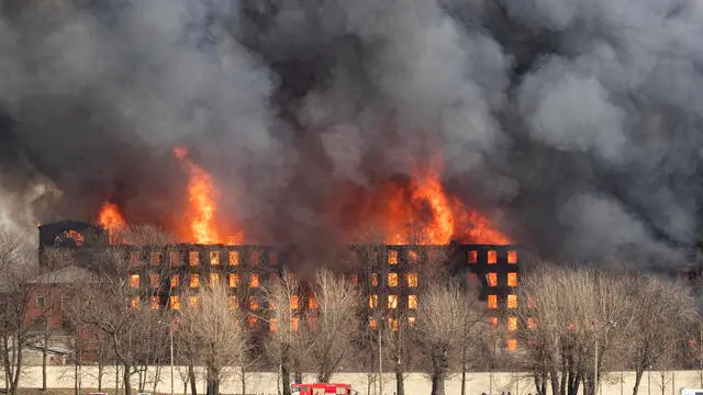 epa09130715 Smoke and fire risees over the building of the factory 'Nevskaya manufactory' located near the Oktyabrskaya embankment of the Neva in St. Petersburg, Russia, 12 April 2021. Some 300 firefighters and 60 pieces of equipment and a helicopter are taking part in extinguishing the fire. One firefighter was killed when extinguishing the fire. EPA/ANATOLY MALTSEV