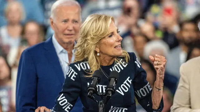 epa11443763 US President Joe Biden (Back) looks on as First Lady Dr. Jill Biden speaks to the crowd during a campaign event at the Jim Graham Building at the North Carolina State Fairgrounds in Raleigh, North Carolina, USA, 28 June 2024. EPA/STAN GILLILAND