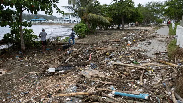 epa11455966 Men look at one of the destroyed docks at the ZarPar marina after the passage of Hurricane Beryl, in Boca Chica, Dominican Republic, 3 July 2024. The Dominican Republic and Haiti emerged almost unscathed from the passage of Hurricane Beryl, whose main effect on the island of Hispaniola, shared by both countries, was the heavy swell that hit the Caribbean coast, and a few electricity and water supply issues. EPA/Orlando Barria