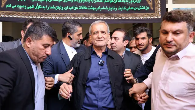 epa11458522 Iranian reformist presidential candidate Masoud Pezeshkian (C) is escorted after casting his vote at a polling station during the presidential election in Ghaleh Hasan Khan, Iran, 05 July 2024. Iran holds the second round of the presidential election on 05 July 2024. EPA/STR