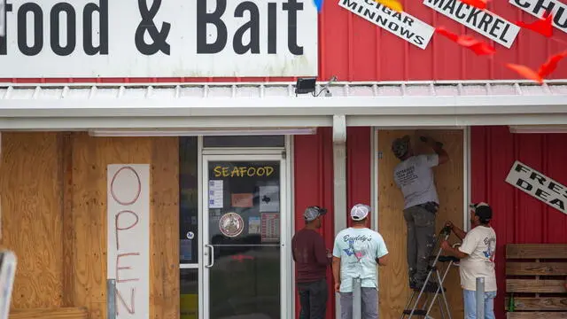 epa11466115 Workers board up the doorway of a business in advance of landfall by Tropical Storm Beryl in Matagorda, Texas, 07 July 2024. The storm is forecast to strengthen into a hurricane overnight and bring high winds and heavy rains to the Texas coast. EPA/CARLOS RAMIREZ