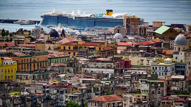 L'agglomerato urbano di case e palazzi di Napoli con il mare e l'ingresso del porto visti dalla collina di Capodimonte , 3 luglio 2024. ANSA / Ciro Fusco