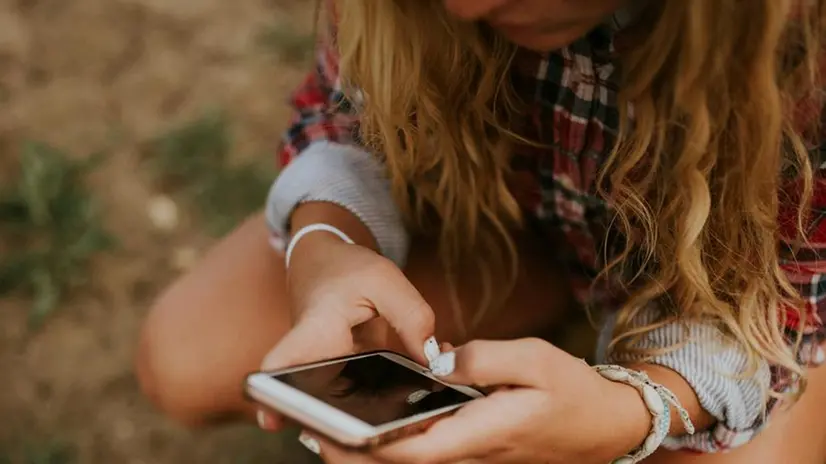 Una ragazza con lo smartphone - Foto Unsplash