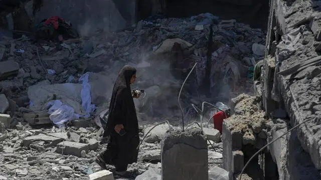 epa11419601 A Palestinian woman walks among the rubble following an Israeli air strike at al-Bureij refugee camp, southern Gaza Strip, 18 June 2024. More than 37,000 Palestinians and over 1,400 Israelis have been killed, according to the Palestinian Health Ministry and the Israel Defense Forces (IDF), since Hamas militants launched an attack against Israel from the Gaza Strip on 07 October 2023, and the Israeli operations in Gaza and the West Bank which followed it. EPA/MOHAMMED SABER