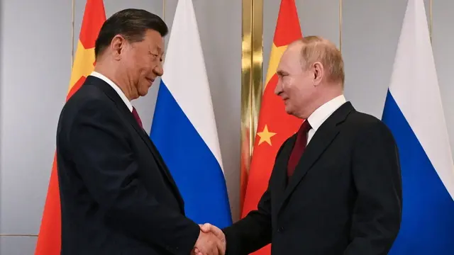 epa11455023 Russian President Vladimir Putin (R) and Chinese President Xi Jinping (L) shake hands as they pose for photos during their meeting on the sidelines of the Shanghai Cooperation Organisation (SCO) summit, in Astana, Kazakhstan, 03 July 2024. The Shanghai Cooperation Organization (SCO) summit takes place in Astana from 03 to 04 July. EPA/SERGEY GUNEEV / SPUTNIK / KREMLIN POOL MANDATORY CREDIT