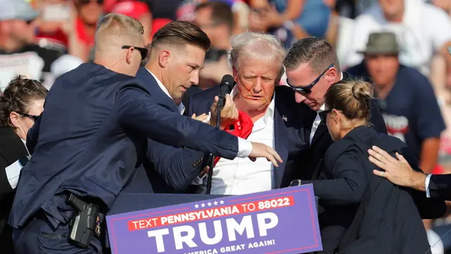 epa11476747 Former US President Donald Trump is rushed off stage by secret service after an incident during a campaign rally at the Butler Farm Show Inc. in Butler, Pennsylvania, USA, 13 July 2024. EPA/DAVID MAXWELL