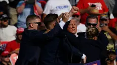 Donald Trump dopo l'attentato alza il braccio in un gesto diventato già iconico - Foto Ansa © www.giornaledibrescia.it