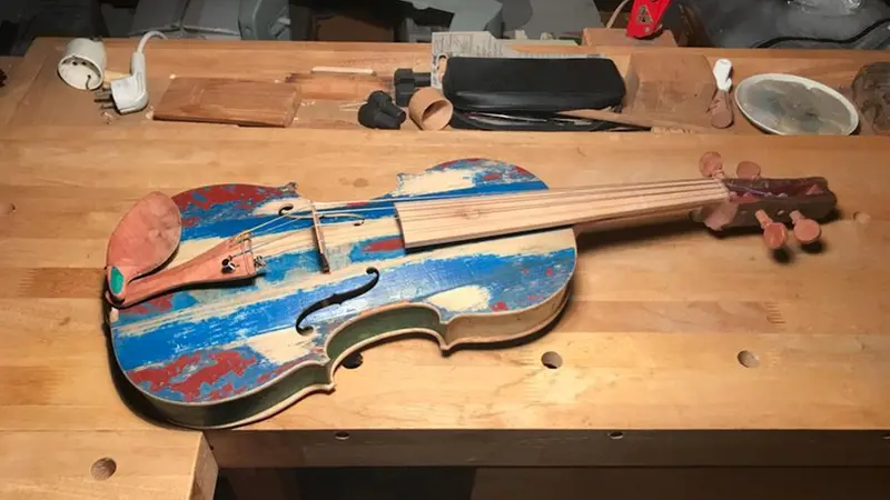 Il violino realizzato con i resti dei barconi dei migranti dai detenuti del carcere di Opera