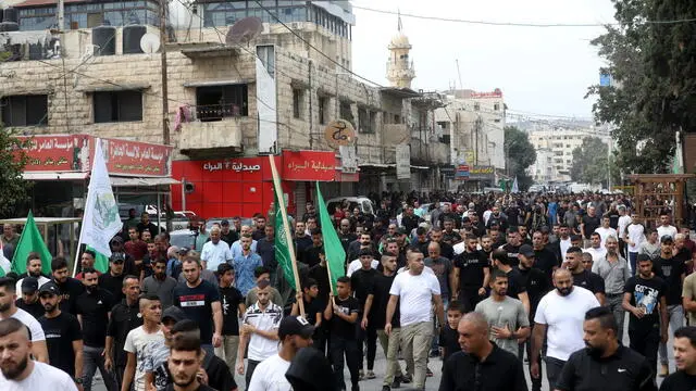 epa10942404 Palestinians attend the funeral procession of people killed in an Israeli army raid in the Jenin refugee camp, in the West Bank city of Jenin, 27 October 2023. At least three Palestinians were killed and eight others were wounded in the operation, the Palestinian Health Ministry said. EPA/ALAA BADARNEH