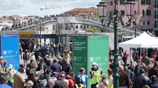 Operatori ai varchi controllano il ticket di accesso sul telefonino di un turista, al check point del piazzale della stazione ferroviaria, Venezia 25 aprile 2024. ANSA/ANDREA MEROLA