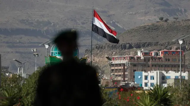 epa11200944 The silhouette of a person walking past a Yemeni flag fluttering in Sana'a, Yemen, 05 March 2024. Yemen's Houthis have claimed responsibility for a drone and missile attack on two US warship destroyers in the Red Sea, in a new action against ships in this important waterway, according to a TV statement by Houthi military spokesman Yahya Sarea. Sarea added his group will step up attacks in the Red Sea until Israel ends its military operation and siege of the Gaza Strip. In light of increased maritime security threats, the US has designated the Houthis as a 'Specially Designated Global Terrorist Group'. EPA/YAHYA ARHAB