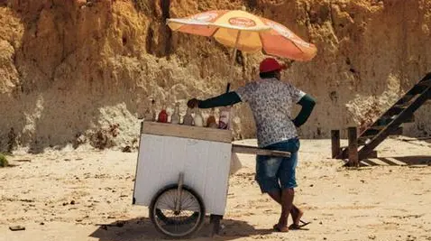 L'uomo del cocco non molla il suo quotidiano giro in spiaggia