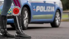 Dettaglio degli stivali di un poliziotto con la paletta infilata dentro, davanti ad una volante della polizia, durante un controllo in strada, in una foto d'archivio. ANSA / POLIZIA DI STATO (simbolica, generica, controlli, polizia, sicurezza, strada)