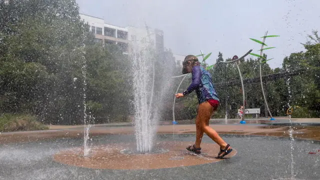 epa10754090 Zia Ausinheiler of Panama stays cool during the hot temperatures while visiting the Historic Fourth Ward Park Splash Pad in Atlanta, Georgia, USA, 18 July 2023. The National Weather Service is predicting a high temperature of 96 degrees Fahrenheit (35.5 Celsius) for Atlanta. A Code Orange air quality alert has also been issued due to Canadian wildfire smoke and ozone. More than a third of Americans are under extreme heat warnings or advisories with records expected to be broken in several cities across the Southern and Western US according to the NWS. EPA/ERIK S. LESSER