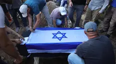epa10950832 Relatives adjust the coffin at the grave of Yosef Vahab, resident of Kibbutz Nir Oz who was killed by Hamas militants in the 07 October attack, during his funeral in Kibbutz Beit Guvrin, Israel, 31 October 2023. More than 8,000 Palestinians and at least 1,400 Israelis have been killed, according to the Israel Defense Forces (IDF) and the Palestinian health authority, since Hamas militants launched an attack against Israel from the Gaza Strip on 07 October, and the Israeli operations in Gaza and the West Bank which followed it. EPA/ABIR SULTAN