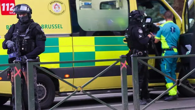 epa10923159 Belgian police officers secure an ambulance car at the scene where the gunman is neutralised in Brussels, Belgium, 17 October 2023. A man, suspected of killing two Swedish football supporters on 16 October, was shot by the Police during an operation and has died, Belgian Police said. Following the incident, the Brussels Capital Region has increased its terror threat to level 4, the highest, the National Crisis Center announced. EPA/OLIVIER MATTHYS