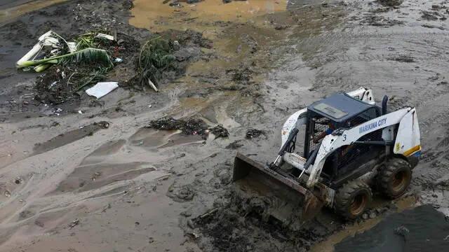 epa11495300 A backhoe is used to clear a road of mud and debris at riverside park in Marikina City, Metro Manila, Philippines, 25 July 2024. A state of calamity was declared in the Philippine capital of Metro Manila and neighboring provinces in order to activate resources to address effects of massive floods from monsoon rainfall caused by typhoon Gaemi on 24 July. Flood evacuees began returning to their homes while other affected families still remain in evacuation centers in need of relief supplies. EPA/ROLEX DELA PENA