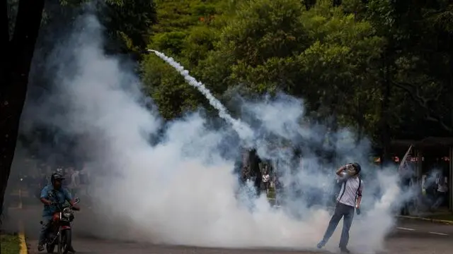 epa07181888 University students clash with the National Bolivarian Police (PNB) during a protest in Caracas, Venezuela, 21 November 2018. The Bolivarian National Police used tear gas to prevent a march of university students, who with the support of the rest of civil society, claim the crisis in the country has affected higher education institutions. The demonstrators were trying to leave the Central University of Venezuela (UCV) in the center of Caracas, where they had previously gathered to discuss the problems of the educational centers, but the PNB officials blocked the exits of the institution with police fences. EPA/MIGUEL GUTIERREZ