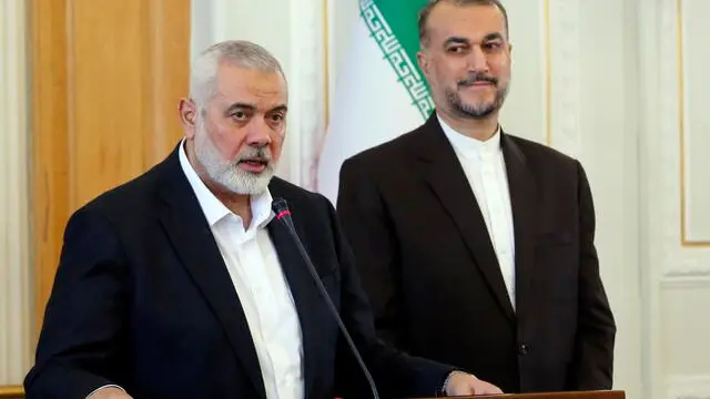 epa11244405 Hamas leader Ismail Haniyeh (L) speaks to the media as Iranian Foreign Minister Hossein Amir Abdoulhian (R) looks on, in Tehran, Iran, 26 March 2024. Haniyeh is in Tehran to meet with Iranian officials. EPA/ABEDIN TAHERKENAREH