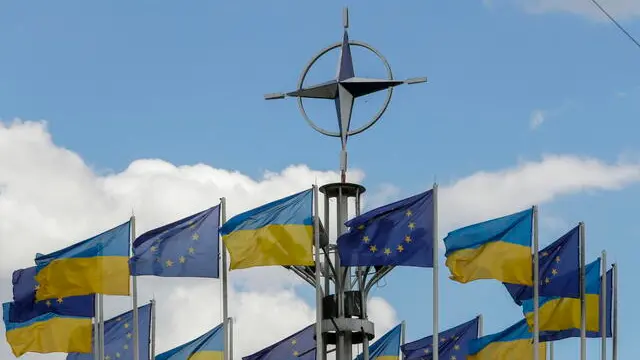 epa10741816 Ukraine's national flags and EU flags fly under the NATO logo in European Square, downton Kyiv (Kiev), Ukraine, 12 July 2023, amid the Russian invasion. The NATO logo was installed in Kyiv in 2019 in connection with the events marking 70 years since the founding of the intergovernmental military alliance. The North Atlantic Treaty Organization (NATO) Summit was held in the Lithuanian capital Vilnius on 11-12 July 2023, where NATO leaders agreed to bring Ukraine closer to NATO. The inaugural meeting of the 'NATO-Ukraine Council' took place on 12 July, where the Allies were joined by Ukrainian President Zelensky. EPA/SERGEY DOLZHENKO