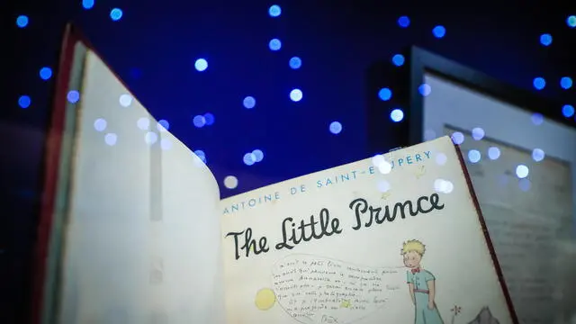 epa09762466 An original English edition of 'The Little Prince' with a dedication by the author on display during the presentation of the exhibition 'A la Rencontre du Petit Prince' (Meet the Little Prince) at the 'Musee des Art Decoratifs de Paris', in Paris, France, 16 February 2022. The exhibition features some 600 artworks by the French writer and designer Antoine de Saint Exupery, including for the first time exhibited in France, the original manuscript dating from 1943 which has since remained in New York. The exhibition runs from 17 February to 26 June 2022. EPA/CHRISTOPHE PETIT TESSON