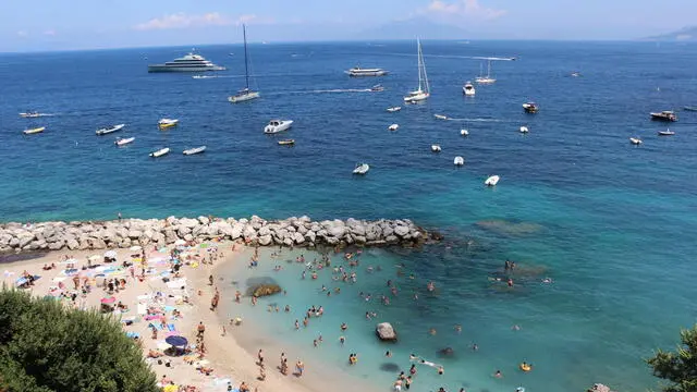 People on the beach enjoy a hot and sunny day in Capri, southern Italy, during Ferragosto, 15 August 2023. Ferragosto is an Italian public holiday celebrated on 15 August every year, coinciding with the major Catholic feast of the Assumption of Mary. It marks the peak of the summer vacation period. ANSA/ GIUSEPPE CATUOGNO