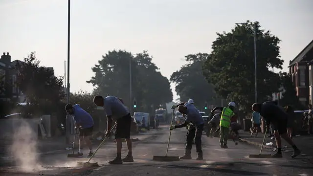 epa11510729 Workers and local residents sweep debris from Sussex Road after a night of disorder in Southport, Britain, 31 July 2024. Merseyside Police issued a statement that 22 Police officers were injured during a night of violent disorder in Southport, with cars set alight & a shop broken into & looted. â€˜A 24-hour Section 60 Order has been introduced and extra officers will remain in the area to provide a visible presence to reassure communitiesâ€™, the police added. EPA/ADAM VAUGHAN